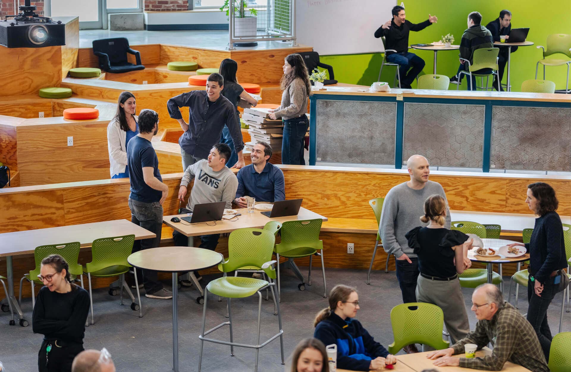 Greentown Labs community members gathering, talking, and working together in the incubator's communal space