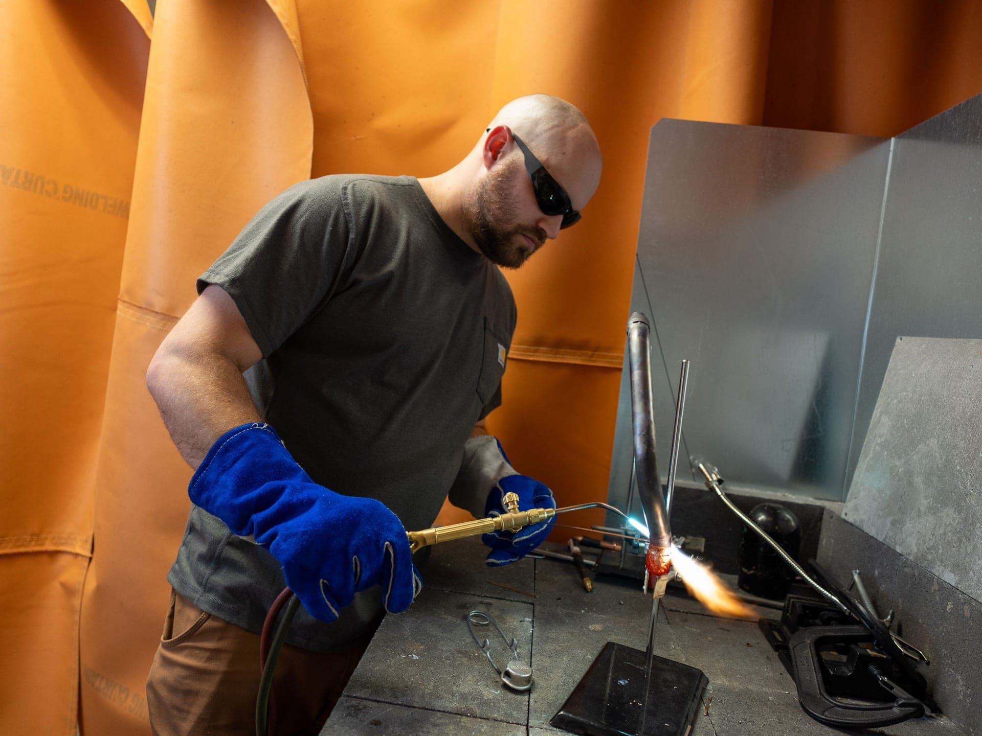 A member welding at a torch station in the prototyping lab