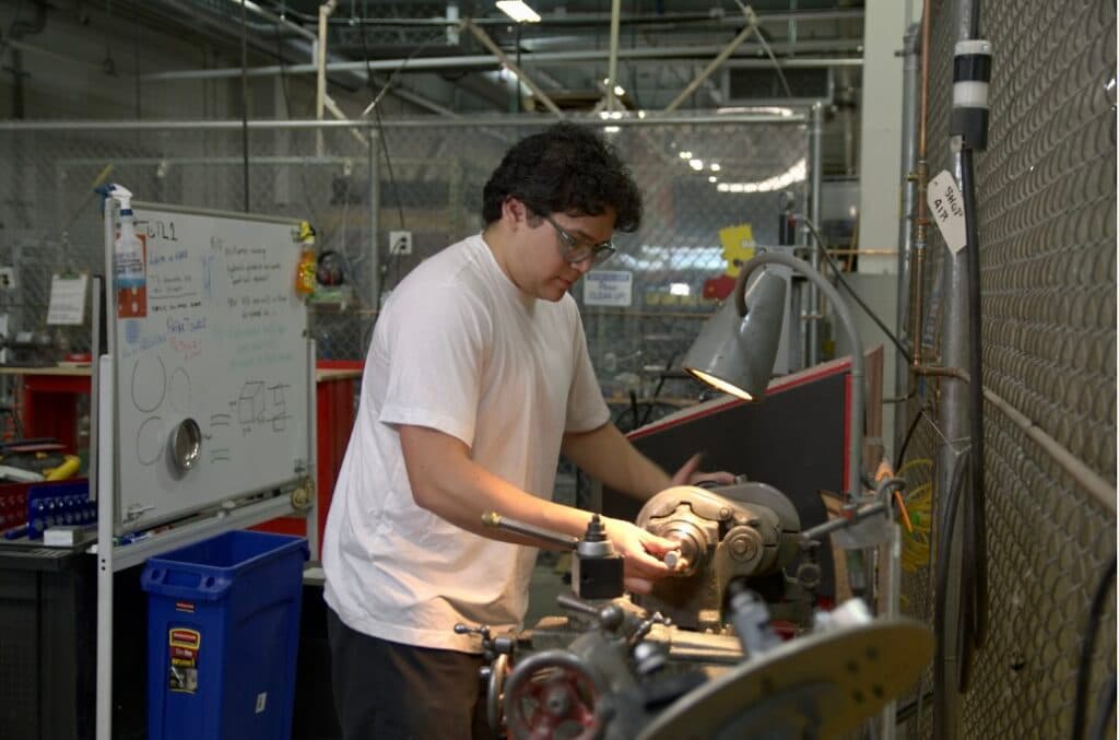 A First Valley Fellow working at a lathe in the Greentown Labs prototyping shop