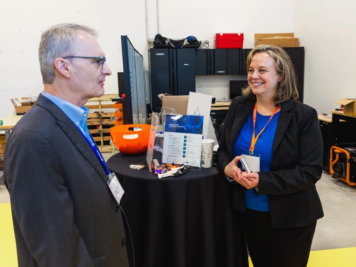 Attendees discussing a decarbonized hydrogen and graphite startup at a past Greentown Houston event