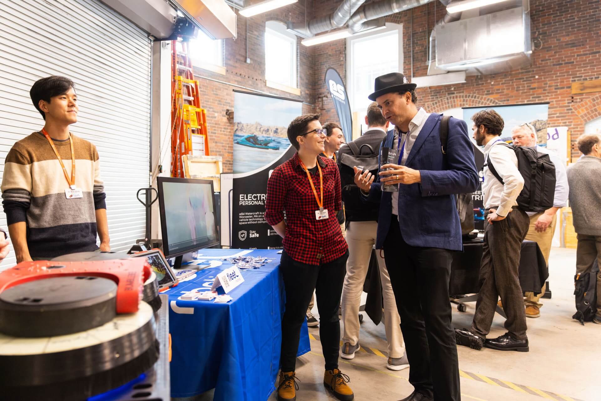 Founders and investors talking at a startup demo booth