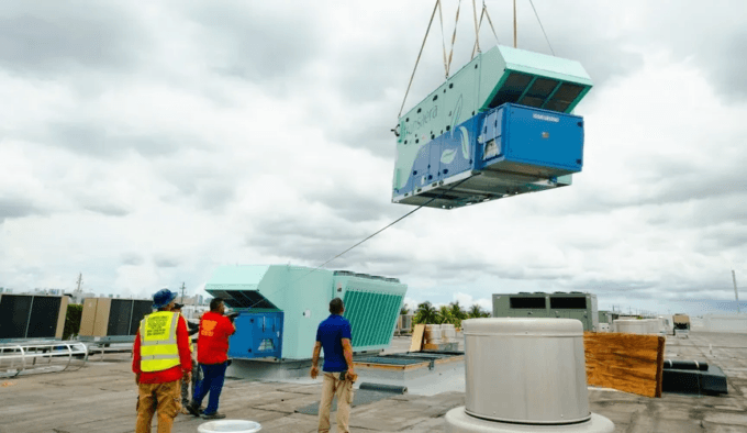 A rooftop HVAC unit being craned into place during installation