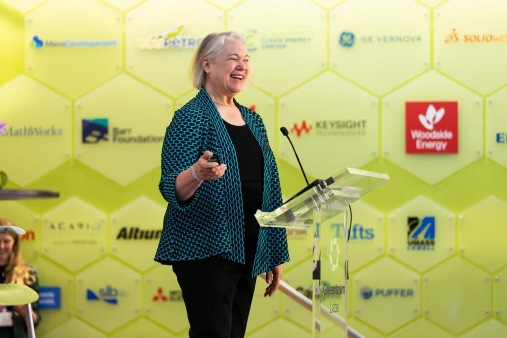 Speaker presenting in front of the Climatetech Summit sponsor wall